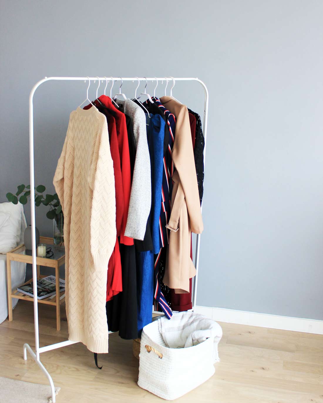 Minimalist curated clothes hanging on a rack for zero waste laundry article.