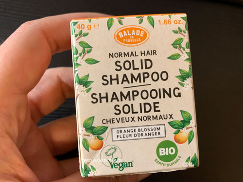 Hand holding a box of solid shampoo for normal hair by Balade en Provence